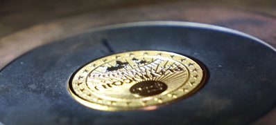 Custom embossing of your Silver coins. A freshly stamped coin in the minting machine